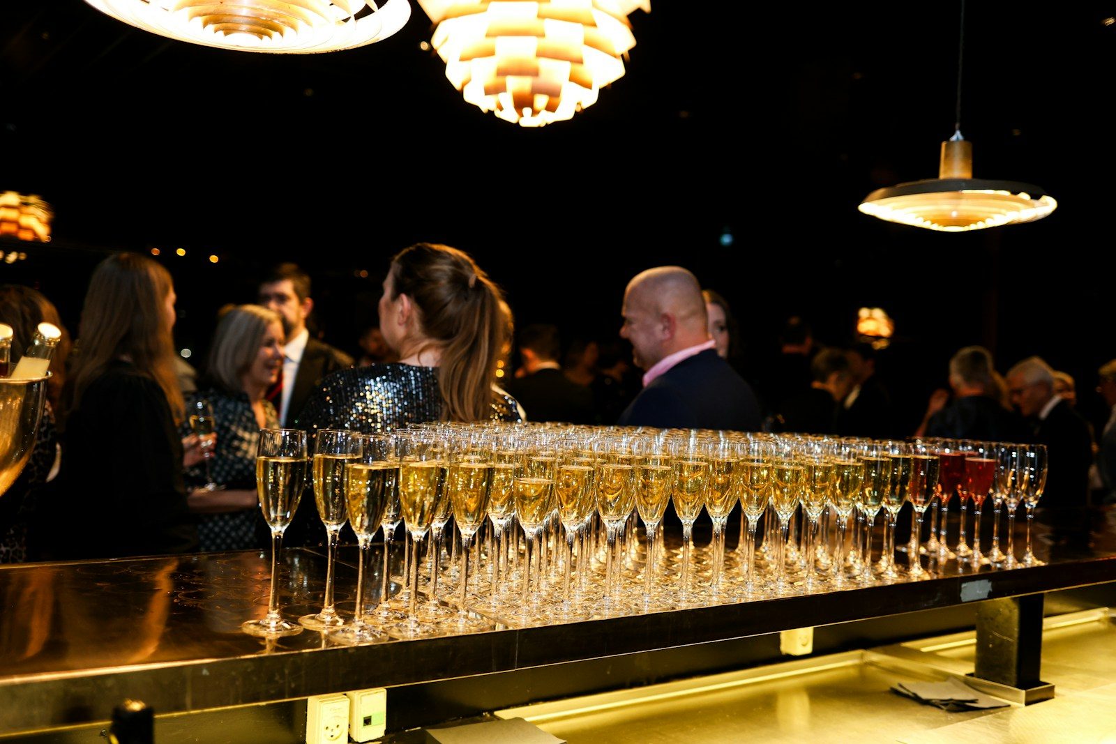 Champagne flutes lined up at a bar